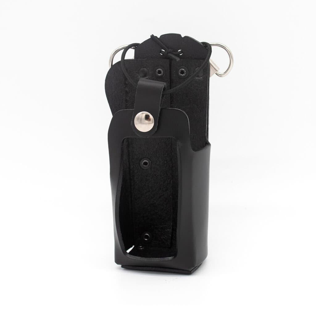 Black leather handgun holster with a securing strap and metal snap, standing upright with a belt loop visible on the back side.
