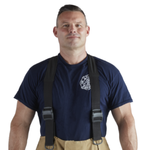 Firefighter in a navy shirt with a fire department emblem and black suspenders, facing the camera.