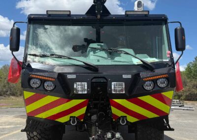 Front view of a black emergency vehicle with red-and-yellow chevron stripes and a roof-mounted camera rig labeled STREAM MASTER on top.