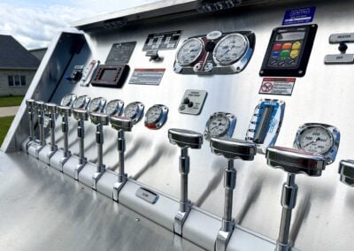 Control panel with multiple gauges, levers, and switches on a stainless metal surface (industrial machinery). The setup includes two large round gauges and a 'Close' button visible at the bottom.