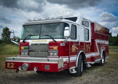 Macon Fire Department fire engine parked in a grassy lot, front view with chrome grille and lights