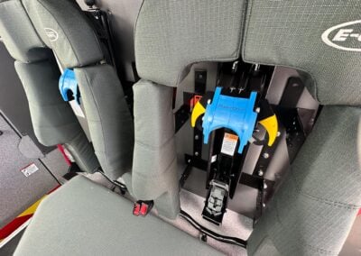 Grey upholstered seat row in a vehicle with blue SmartDock docking hardware on the seat bases.
