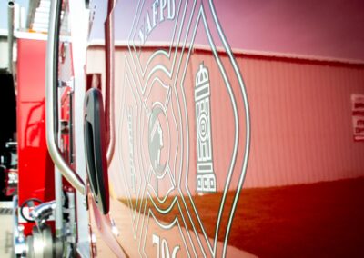 Close-up of the side of a red fire truck showing a large circular emblem and text