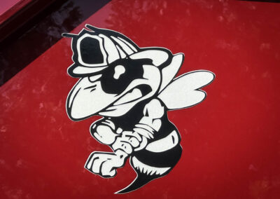 Close-up of a black-and-white cartoon dog logo on a red background.