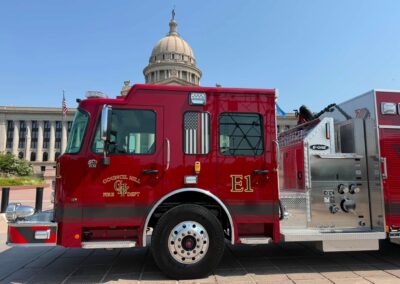 Red fire truck in the foreground with a domed government building and an American flag in the background